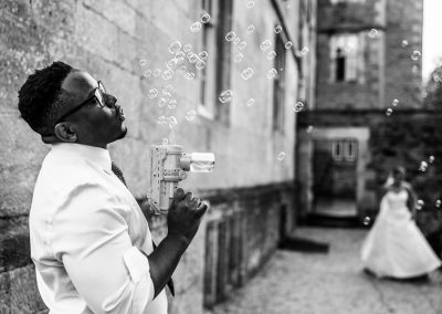 Male wedding guest blowing bubbles