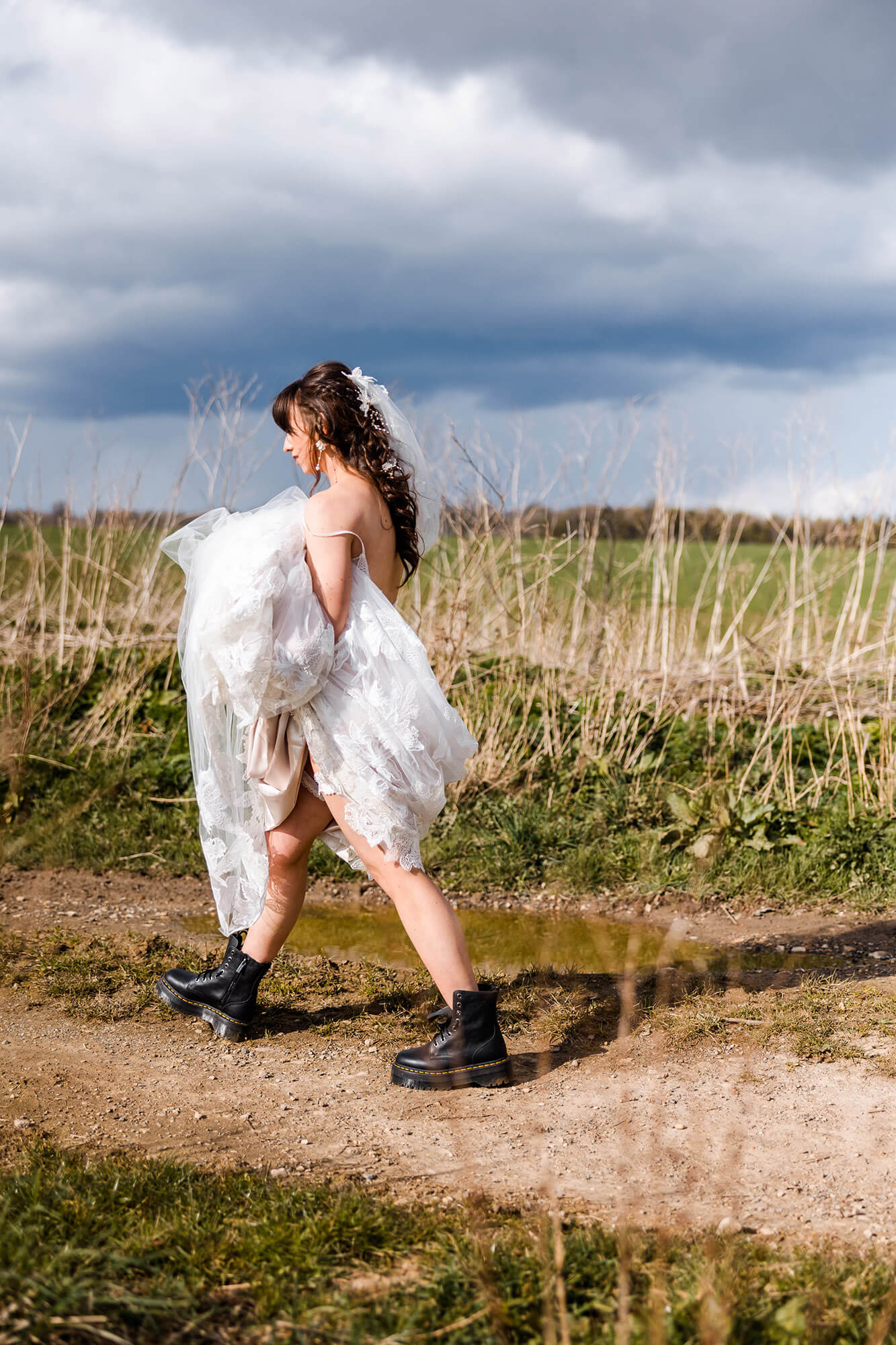 Bride walking through mud in her Dr Martins