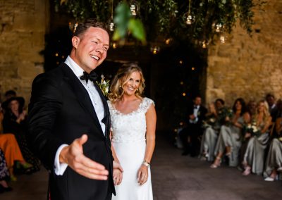 Bride and groom at their ceremony i front of the glass doors of Stone Barn